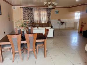 a dining room with a table and chairs and a couch at M Palace Guest House in Kempton Park