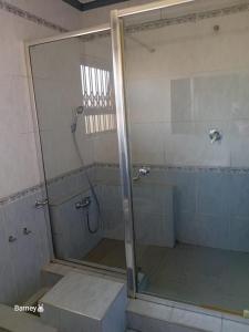 a shower with a glass door in a bathroom at M Palace Guest House in Kempton Park
