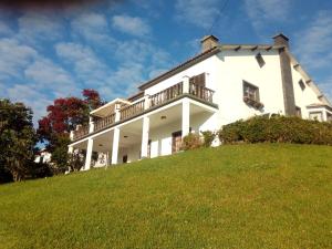 uma grande casa branca no topo de uma colina em Quinta do Quarteiro em Povoação