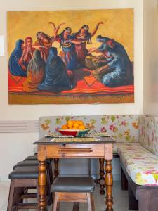 una sala de estar con una mesa y una pintura en la pared en Appartement lumineux avec Jardin à la palmeraie, en Marrakech