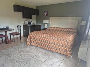 a bedroom with a bed and a kitchen and a table at Maple leaf motel in New Milford