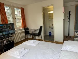 a bedroom with a bed and a television and a table at Charming Riverside Studio - Stork 41 in Zurich