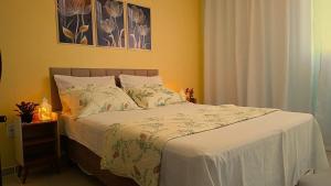 Un dormitorio con una cama con un edredón blanco. en Residência Lima, en Cabo Frío