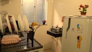 Una cocina con refrigerador y un mostrador con cuchillos. en Residência Lima, en Cabo Frío 10 fotos más