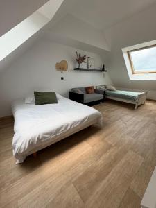 ein Schlafzimmer mit einem Bett und einer Couch und einem Fenster in der Unterkunft Charmante Maison Néo-bretonne in Perros-Guirec