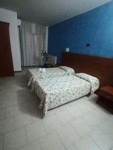 a bedroom with a bed and a blue wall at Ristorante Antonio e Davide in Bellante