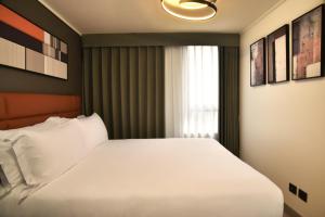 a bedroom with a white bed and a window at Apart Hotel HW Compañia in Santiago +14 photos
