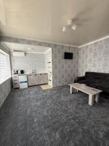 a living room with a couch and a table at Kubat Guest House in Tokmok