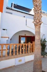 a palm tree in front of a building with a balcony at CasasQuesada in Ciudad Quesada