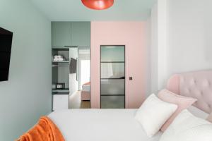 1 dormitorio con 1 cama con cabecero rosa y espejo en Charm Beach Retreat, en Alicante