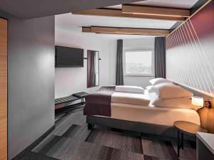 a bedroom with a bed and a flat screen tv at B&B Hotel Hamm in Hamm +20 photos