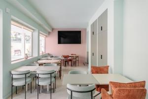 Un restaurante con mesas y sillas y un televisor de pantalla plana. en Charm Beach Retreat, en Alicante