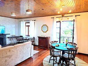 a living room with a couch and a table at Charme nas montanhas com lareira in Campos do Jordão +76 photos