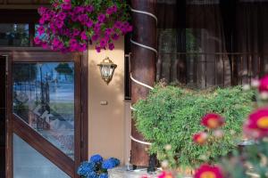 Un edificio con un ramo de flores al lado de una puerta. en Balkan Hellas, en Leptokarya