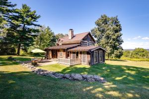 a large house on a grass field with trees at Cabin Vacation Rental about 8 Mi to Penn State! in State College