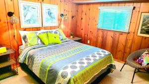 a bedroom with a bed with green pillows and a window at Milton's Cottage in Lake Milton