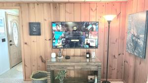 a room with a tv on a wooden wall at Milton's Cottage in Lake Milton