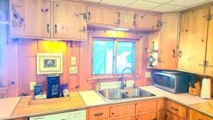 a kitchen with a sink and a microwave at Milton's Cottage in Lake Milton +26 photos
