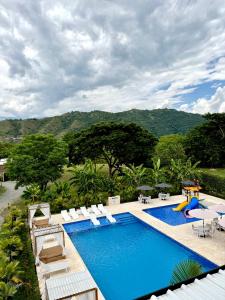 an outdoor swimming pool with chairs and a slide at Ivanna Hotel Campestre - Santa Fe de Antioquia in Santa Fe de Antioquia