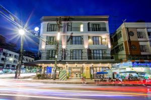 a building on a city street at night with traffic at Snoozz Hotel Krabi in Krabi town