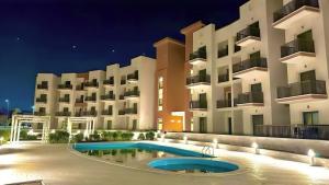 a large apartment building with a swimming pool at night at الفيروز in 6th Of October +13 photos