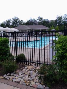 ein schwarzer Metallzaun mit einem Swimmingpool in der Unterkunft Beautiful Apartment in Concord with swimming pool and Gymn in Charlotte