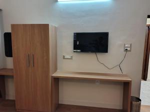 a flat screen tv on a wall in a room at Krishna Hotel in Dehradun