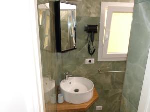 ein Badezimmer mit einem weißen Waschbecken und einem Spiegel in der Unterkunft The column of Campo de' Fiori in Rom