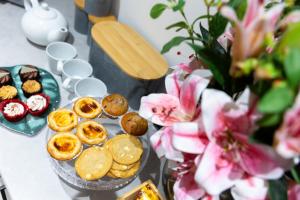 une table garnie de biscuits, de pâtisseries et de fleurs dans l'établissement #61 Spacious 3-Bedroom House at 163 Bolingbroke Rd, à Parkside