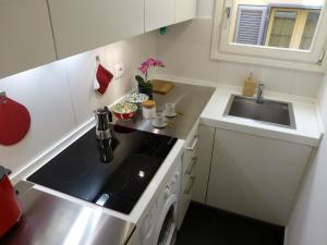 a small kitchen with a sink and a stove at The little column in Rome