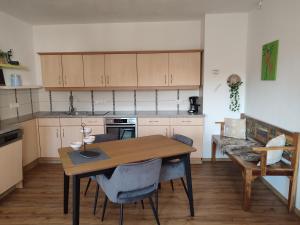 a kitchen with a wooden table and chairs in a room at Fewo Puxberg in Niederwölz