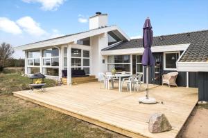 a wooden deck with a table and an umbrella at LN1911-Hjorring-Under-Bjergene-3 in Hjørring