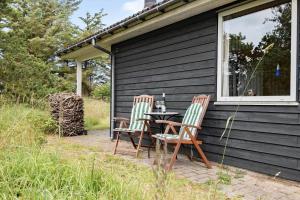 two chairs and a table on the side of a house at LN1965-Hirtshals-Klinken-11 in Hirtshals