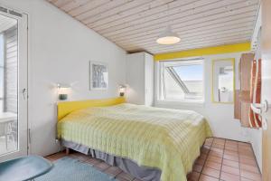 a bedroom with a yellow bed and a window at LN1963-Hirtshals-Klynen-19 in Hirtshals