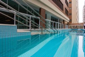 a swimming pool in front of a building at Unique, Ex-Estanconfor, VISTA MAR apto 1510 in Santos
