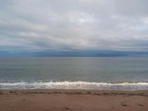 a beach with the ocean on a cloudy day at Le nid marin in Gascons +10 photos