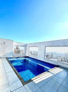 Cobertura Vista Mar com Piscina Privativa - PG في برايا جراندي: مسبح على جانب مبنى