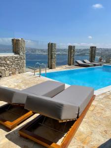 a bed on the side of a swimming pool at Natural Stone Villa II in Mýkonos City