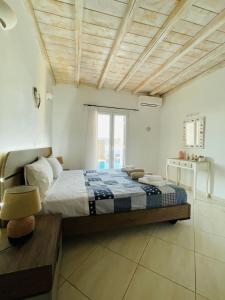 a bedroom with a large bed with a wooden ceiling at Natural Stone Villa II in Mýkonos City