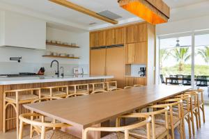 a kitchen with a large wooden table and chairs at The Fairhaven House at Solaire Lunara Bay in Key West