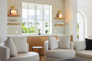 a living room with two chairs and a window at The Fairhaven House at Solaire Lunara Bay in Key West +55 photos