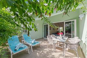a patio with blue chairs and a table and chairs at Casa Verde - Blije Rust I in Sint Michiel