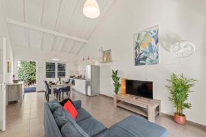 a living room with a blue couch and a tv at Casa Verde - Blije Rust I in Sint Michiel