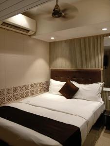 a bedroom with a large bed with white pillows at KALPANA RESIDENCY - A Family Hotel in Mumbai