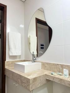 a bathroom with a sink and a mirror at Pousada Vila Caetité Lofts in Caetité