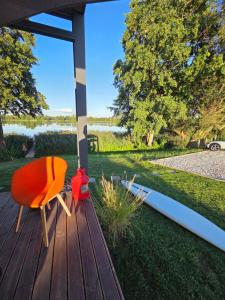 an orange chair sitting on a deck with a view of a yard at Skryjówka in Chrzypsko Wielkie