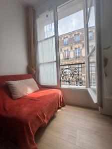 a bedroom with a bed and a large window at Coliving Marais in Paris
