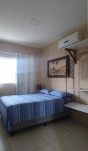 a bedroom with a bed with a blue comforter at Chalés Aconchego da Serra in Sairé +58 photos