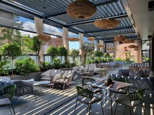 a restaurant with tables and chairs and windows at Vila Borova Wellness&SPA Resort in Zlatibor