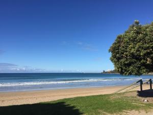 a beach with a fence and a tree and the ocean at Cora Lynn - Apartment 18 in Lorne